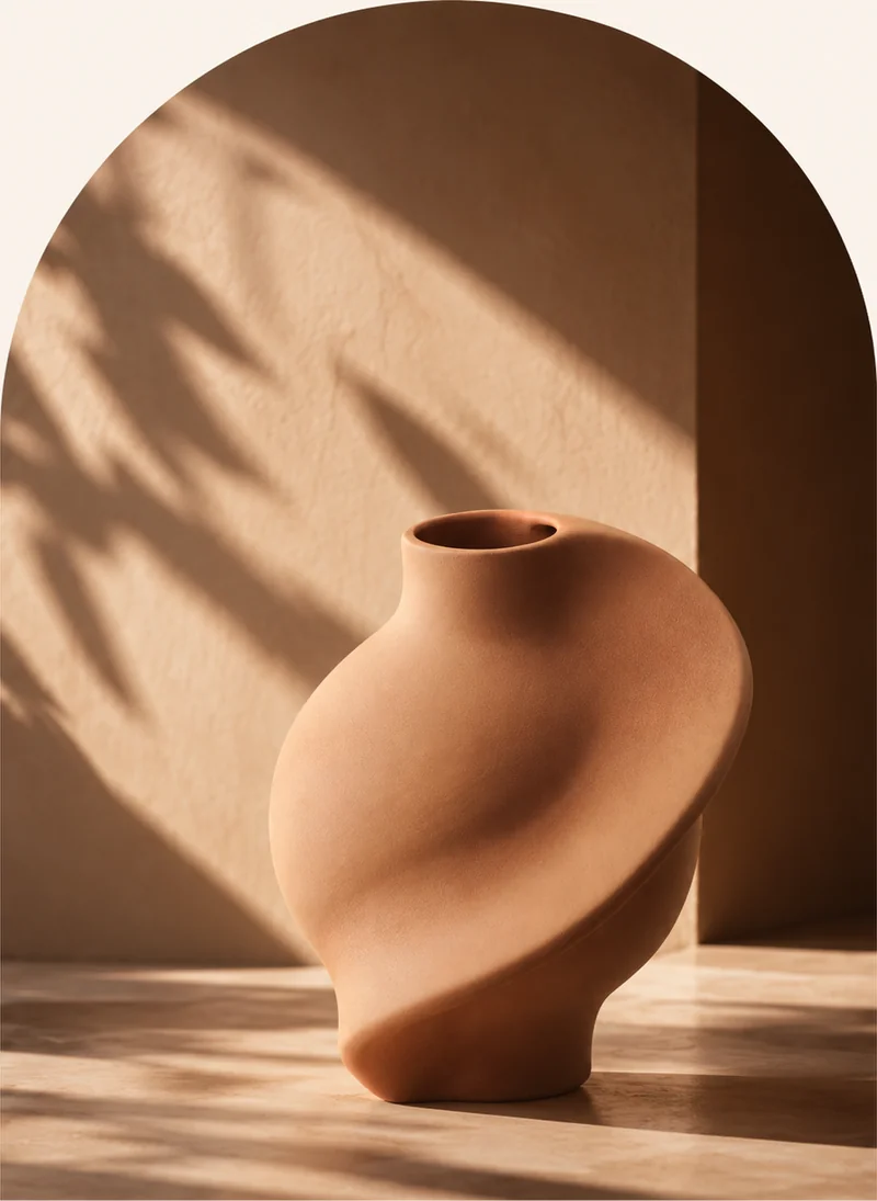 Sculptural terracotta vase in warm arched light